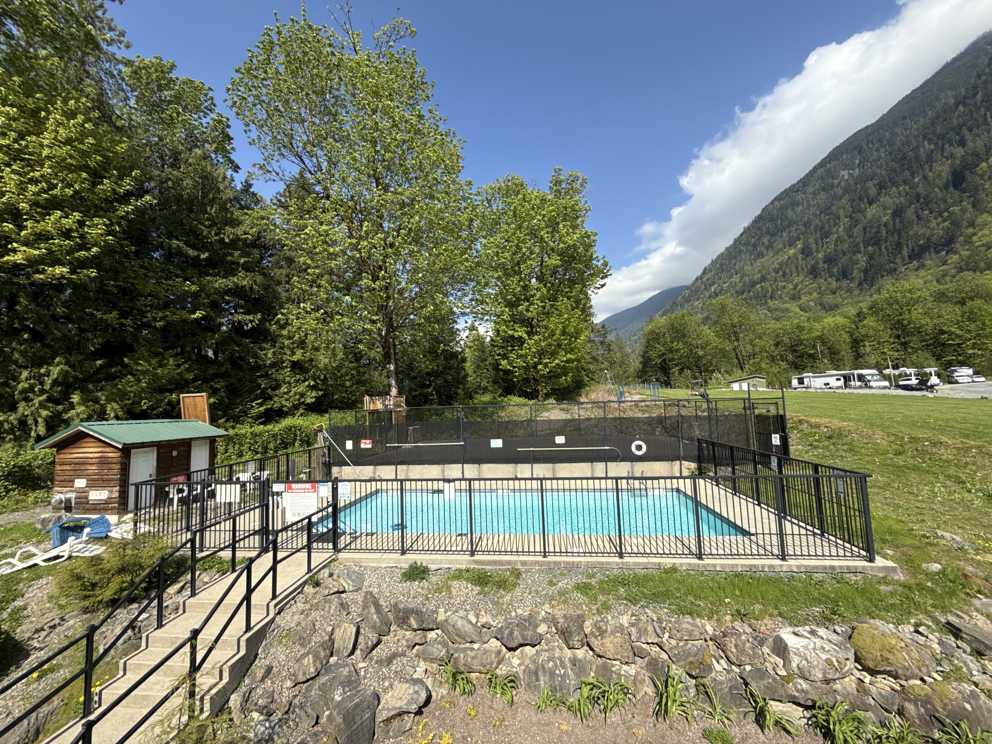 The outdoor pool with forested mountains rising directly behind